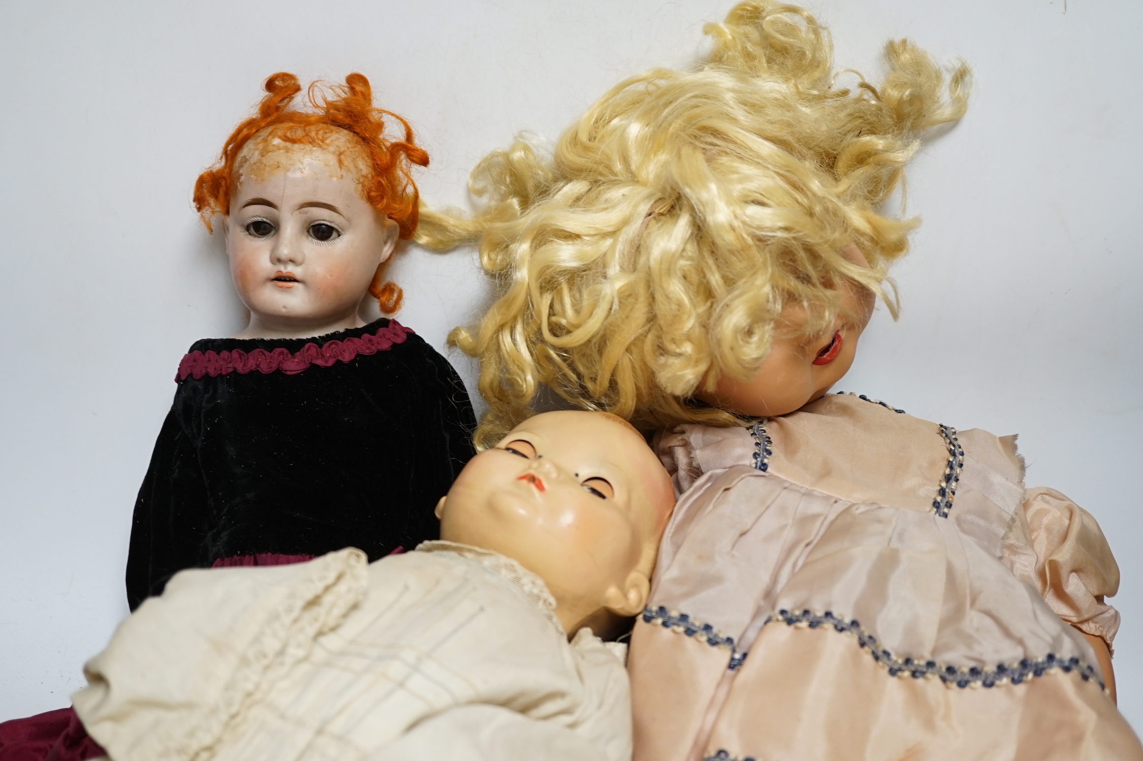 Three dolls; a German Bisque shoulder head doll with sleeping eyes with jointed kid leather body, 46cm, an English celluloid doll and another